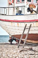 Ladder leunend tegen oude vissersboot