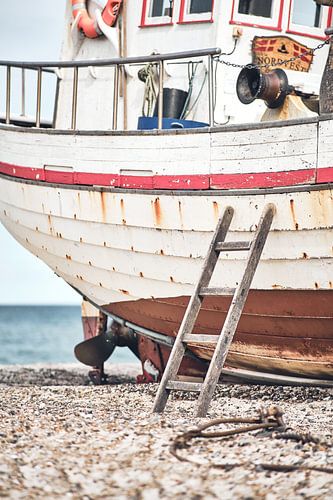 Ladder leaning against old fishing boat