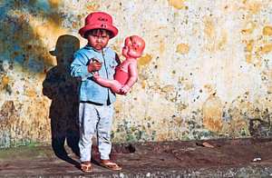 Vietnamesisches Mädchen mit Puppe im Arm 