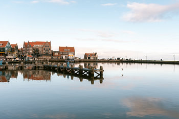 Een uitzicht met reflectie op de dijk en steiger in Volendam