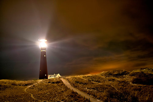 Lighthouse and fishermen's cottages in the night at the island of Schiermonnikoog