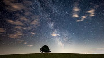 Milky way over the Muglhof chapel in Bavaria with light clouds
