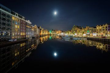 De maan boven het Damrak in Amsterdam