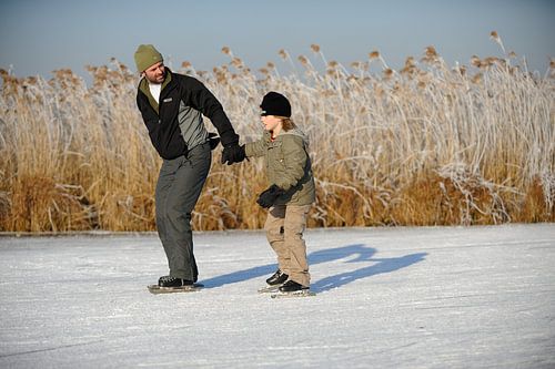 Vater und Sohn beim Schlittschuhlaufen auf den Nieuwkoop-Seen von Merijn van der Vliet