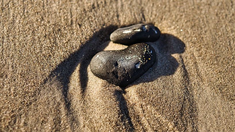 Heart-shaped stone in the sand of the Baltic Sea beach by Martin Köbsch