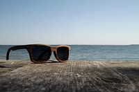 Sunglasses on wood on the coast