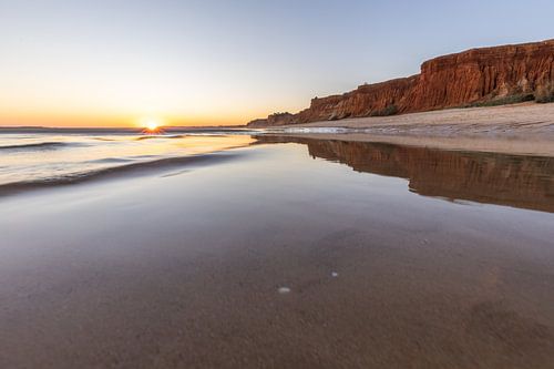 Zonsondergang op het zandstrand Praia da Falésia. Kliffen Roze bloemen bij Albufeira, Portugal