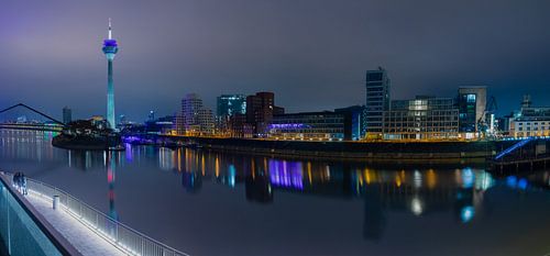 Panorama van de skyline van Düsseldorf tijdens de avond met de Rijn Toren.