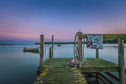Zonsondergang aan de steiger van de zee.