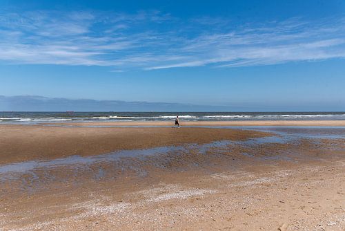 Noordzeestrand met eenzame wandelaar
