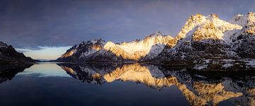 Het fjord met de bergen in het laatste zonlicht