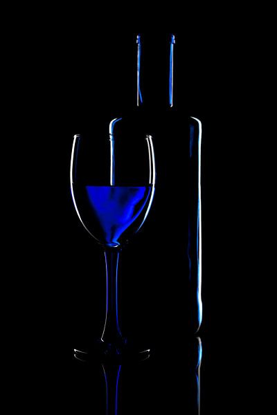 Abstract photo with a glass and a wine bottle on black background by Jolanda Aalbers