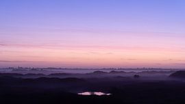 Fog covers the dunes and trees on Terschelling at dusk by Alex Hamstra