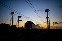 Een Intercity tussen Weesp en Diemen net na zonsondergang