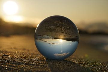 View through the glass ball on the beach. Sea and sky in the background. by Martin Köbsch