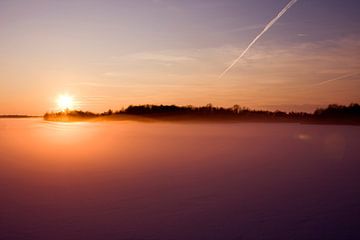 Ondergaande zon en mist over het meer van Sandra de Heij
