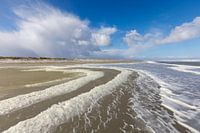 Schaum am Strand von Ameland bei schönem, bewölktem Himmel