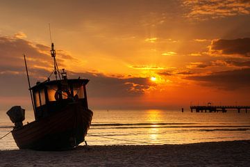 Vissersboot op het strand van de Oostzee bij zonsopgang