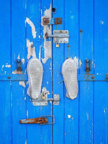 Porte bleue avec serrures et une paire de chaussures
