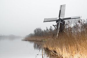 Molen in het landschap aan het water op een mistige dag
