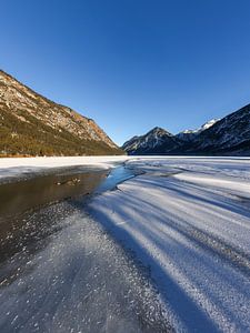 Licht und Schatten am gefrorenen See in den Tiroler Alpen