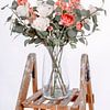 Vaas met mooie bloemen op een houten trap van Miranda van Hulst