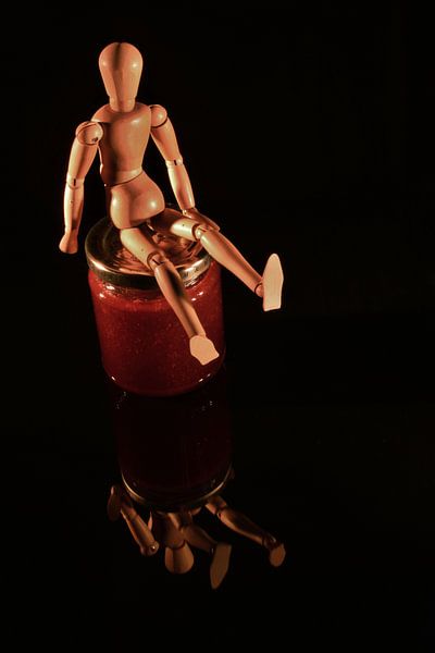 Obstkonserven mit Holzpuppe und schwarzem Hintergrund von Hans-Jürgen Janda