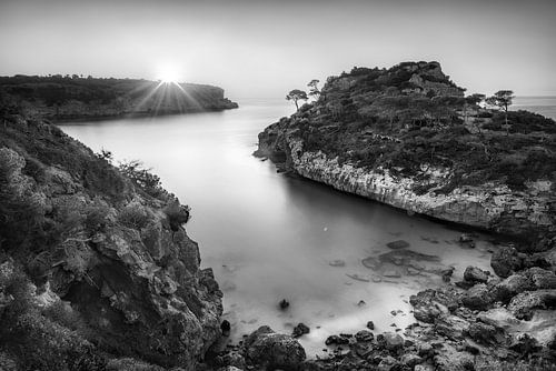 Zonsopgang bij een mooie baai in Mallorca in zwart-wit.