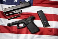 Pistolet démonté gisant sur le drapeau américain.