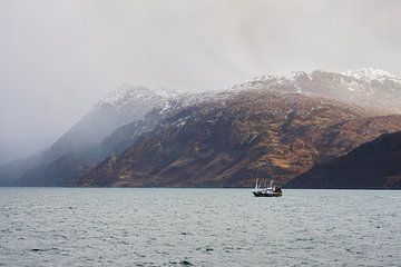 eenzame boot bij een Schotse Glen met wilde kust, regenbuien en sneeuw van Leo Schindzielorz