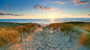 Sonnenuntergang an einem Strandeingang an der Nordsee
