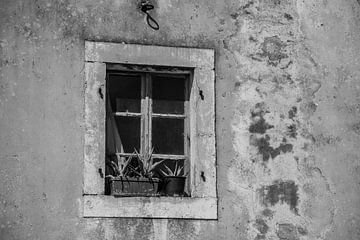 Verwitterte Fassade mit Fenster in schwarz-weiß