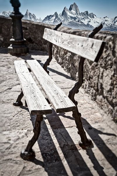 Wooden bench in front of mountain scenery by Uwe Merkel