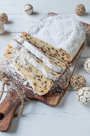 Hausgemachter Weihnachtsstollen auf einen rustikalen Brett auf weißen Hintergrund von Authentic Food Stories