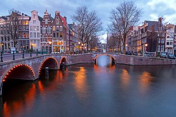 Stadsgezicht van Amsterdam in Nederland bij avond van Eye on You