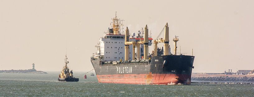 Cargo ship with tug underway near IJmuiden. by scheepskijkerhavenfotografie