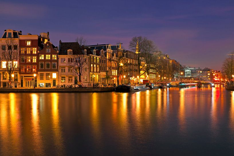 Stadsgezicht van Amsterdam bij nacht in Nederland van Eye on You