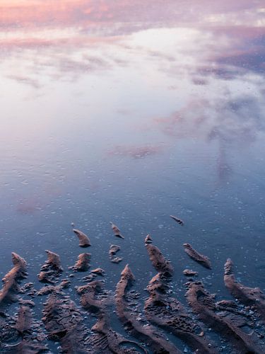 Ondergaande zon weerspiegeld in opkomend water