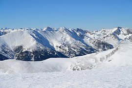 Schneebedeckte Berggipfel unter einem strahlend blauen Winterhimmel von Tomherkules