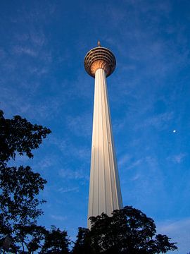 De KL (Kuala Lumpur) Tower tegen een blauwe hemel met maan in Kuala Lumpur van Niek
