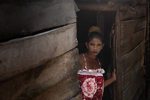 Vrouw met beschilderd gezicht bij woning in Ifaty, Madagaskar