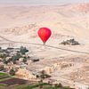 Montgolfière rouge au-dessus des temples anciens de Louxor, Égypte sur Bart van Eijden