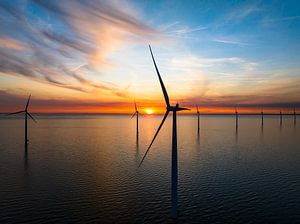 Windturbinen in einem Offshore-Windpark bei Sonnenuntergang