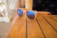 Sunglasses with reflection on a wooden table