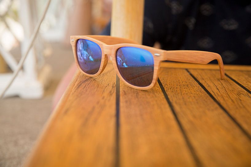 Sunglasses with reflection on a wooden table by Esther esbes - kleurrijke reisfotografie