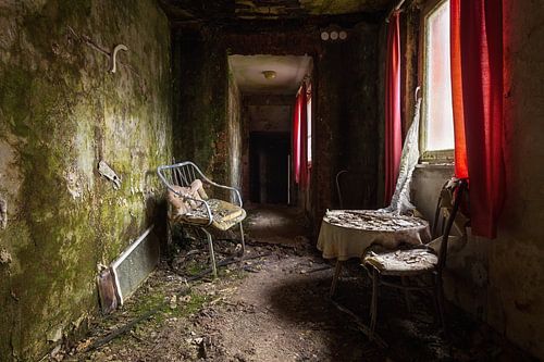 Hôtel abandonné avec rideau rouge.