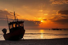 Bateau de pêche sur la plage au lever du soleil