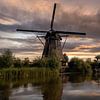Zonsondergang met molen aan water. van René Ouderling