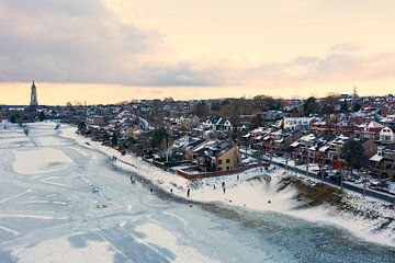 Luchtfoto van het besneeuwde stadje Rhenen aan de Nederrijn met zonsondergang van Eye on You