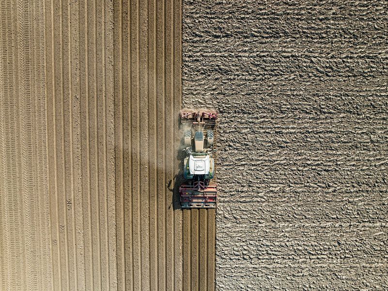 Tractor maakt de grond klaar voor het planten van gewassen van bovenaf gezien van Sjoerd van der Wal Fotografie